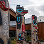 Carved wooden poles representing various animals.