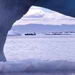 Une coulée de glace en train de fondre avec des chasseurs au loin.